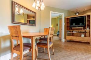 a dining room with a table and chairs and a mirror at Days Inn by Wyndham Berthierville in Berthierville