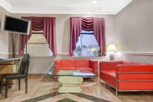 sala de estar con muebles de color rojo y TV en Super 8 by Wyndham Galveston en Galveston