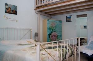 a bedroom with a white bed and a painting on the wall at AGRITURISMO B&B BIO LA TANA DEL LELE in Serra San Quirico