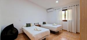 a room with two beds and a window at Finca con piscina rodeada de naturaleza in Sencelles +8 photos