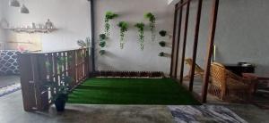 a living room with a green floor with plants at Cozy Nature Homestay - Free Wifi Disney Hotstar ADS in Nibung Tebal