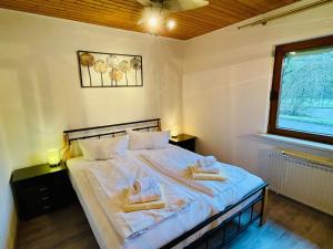 a bedroom with a bed with two towels on it at Bungalow am Fuße der Wasserkuppe in Dipperz