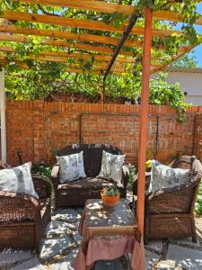 a patio with wicker furniture and a wooden pergola at Egerton Overnight in Kimberley