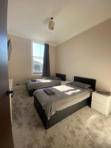 a bedroom with two beds and a window at South Chelsea Room London in London