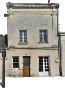 duży ceglany budynek z drzwiami i trzema oknami w obiekcie Halte Loire w mieście Saumur