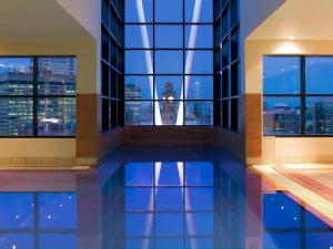 a pool in a building with a view of the clock tower at Mercure Sydney in Sydney