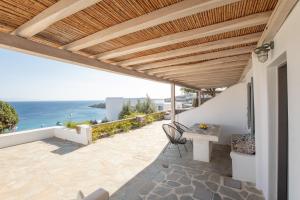 a patio with a table and a view of the ocean at Blue Moon Mykonos Homes in Mýkonos City