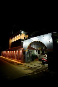 a lit up building with cars parked in a parking lot at Utsav Hotels and Banquets Bolpur, Shantiniketan in Bolpur