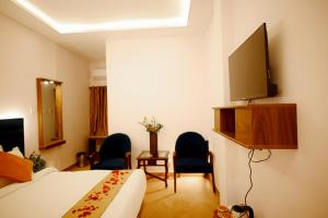 a hotel room with a bed and a flat screen tv at Utsav Hotels and Banquets Bolpur, Shantiniketan in Bolpur