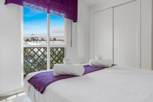 een slaapkamer met een groot wit bed en een raam bij Great 2-Bed Apartment in Nueva Andalucia Marbella in Marbella
