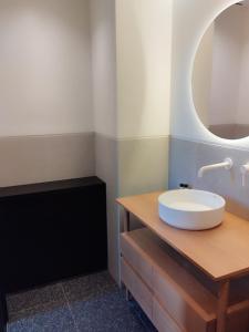 La salle de bains est pourvue d'un lavabo blanc et d'un miroir. dans l'établissement Athens Tower Hotel by Palladian Hotels, à Athènes