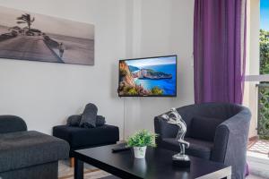 een woonkamer met een tv aan de muur bij Great 2-Bed Apartment in Nueva Andalucia Marbella in Marbella