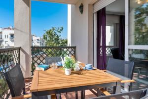 een houten tafel en stoelen op een balkon bij Great 2-Bed Apartment in Nueva Andalucia Marbella in Marbella
