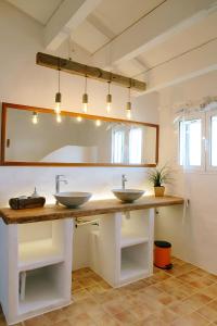 a bathroom with two sinks and a large mirror at Heretat de Sant joan in Ferreries