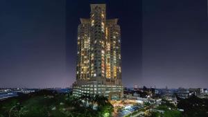 een hoog gebouw wordt 's nachts verlicht bij Best Western Mangga Dua Hotel & Residence in Jakarta