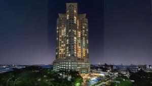 a tall building is lit up at night at Best Western Mangga Dua Hotel & Residence in Jakarta