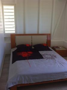 1 dormitorio con 1 cama grande y cabecero de madera en Villa QUIETUDE, en Sainte-Anne