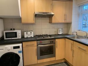 a kitchen with a stove and a microwave at 1-Bedroom Apartment in Balham with Free Parking - near Tube Station in London