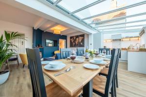 ein Esszimmer und eine Küche mit einem Holztisch und Stühlen in der Unterkunft Golf Cottage in West Runton