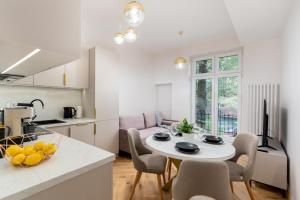 cocina y sala de estar con mesa y sillas en Luxury apartment with a sauna and bedroom with bath, en Cracovia
