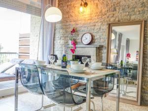 Vinyet Tranquility by Hello Homes Sitges في سيتجيس: غرفة طعام مع طاولة مع كراسي وساعة