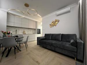sala de estar con sofá negro y mesa en VipWarsawApartments pl Gold Mennica Residence, en Varsovia