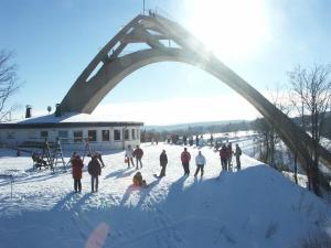 a group of people standing in the snow under a bridge at Das kleine Försterhaus in Winterberg +4 photos