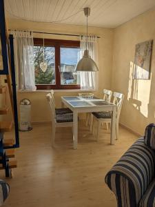a dining room with a white table and chairs at Das kleine Försterhaus in Winterberg