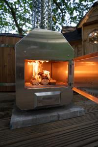a oven on a deck with food in it at Chestnut Tree House with Hot tub & Sauna in Barmouth
