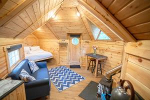 a room with a bed and a couch in a cabin at Chestnut Tree House with Hot tub & Sauna in Barmouth