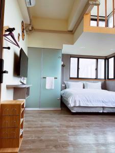 a bedroom with a bed and a flat screen tv at Xianwang Homestay in Jincheng