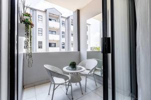 a balcony with a table and chairs and a window at Central Serenity @Midrand in Midrand