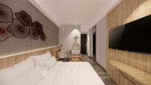 a bedroom with a large bed and a flat screen tv at Mc Hotel Fairview in Manila