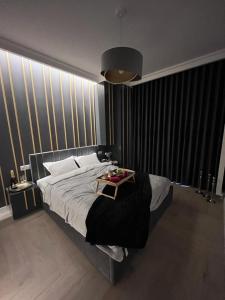 Un dormitorio con una cama con una mesa. en VipWarsawApartments pl Gold Mennica Residence, en Varsovia