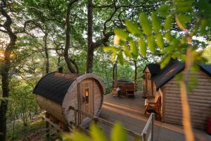 a wooden deck with a cabin in the woods at Chestnut Tree House with Hot tub & Sauna in Barmouth