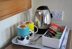 a kitchen counter with two cups and a coffee maker at Abbey Guest House York in York