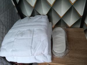 uma cama com lençóis brancos num quarto com uma parede em Ze Oni Glamping em Tbilisi