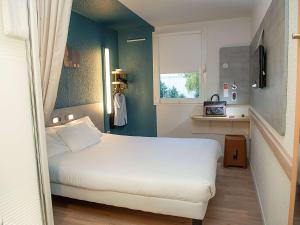 1 dormitorio con cama blanca y ventana en Ibis Budget Le Havre Les Docks, en Le Havre