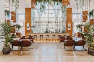 a lobby with a bar with chairs and plants at TUl BLUE Xanthe - Ultra All Inclusive in Side +40 photos
