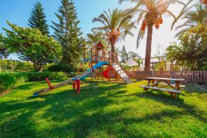a playground with a slide and a picnic table at Xanthe Resort & SPA in Side