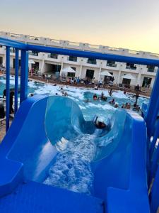 沙姆沙伊赫的住宿－Sharm Cliff Hotel，一个人在游泳池里骑水滑梯