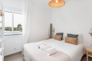 a bedroom with a white bed with towels on it at TAC - Sagres Studio in Sagres