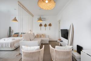 a white living room with a couch and chairs at TAC - Sagres Studio in Sagres +12 photos