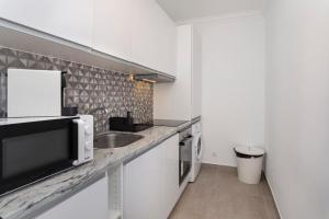 a kitchen with a sink and a microwave at TAC - Sagres Studio in Sagres