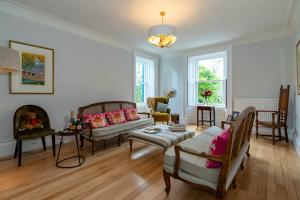 uma sala de estar com um sofá e uma mesa em Rosebank House - 12 Guests, 6 Ensuite Bedrooms, EV point, Games Rooms, Wood Burner, Pet Friendly! em Blairgowrie