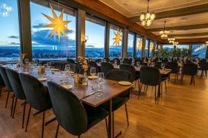 a dining room with tables and chairs and large windows at Radisson Blu Resort, Beitostølen in Beitostøl