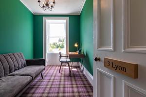 een woonkamer met groene muren en een bank bij Rosebank House - 12 Guests, 6 Ensuite Bedrooms, EV point, Games Rooms, Wood Burner, Pet Friendly! in Blairgowrie
