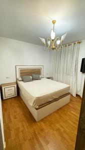 Un dormitorio con una cama grande y una lámpara de araña. en Galu, en Vilagarcía de Arousa