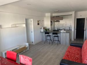 a living room and kitchen with a couch and chairs at Quarteira SeaViews in Quarteira