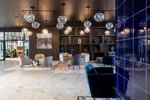 a lobby with chairs and tables and lights at Radisson Blu Resort & Conference Center, Ostróda Mazury in Ostróda